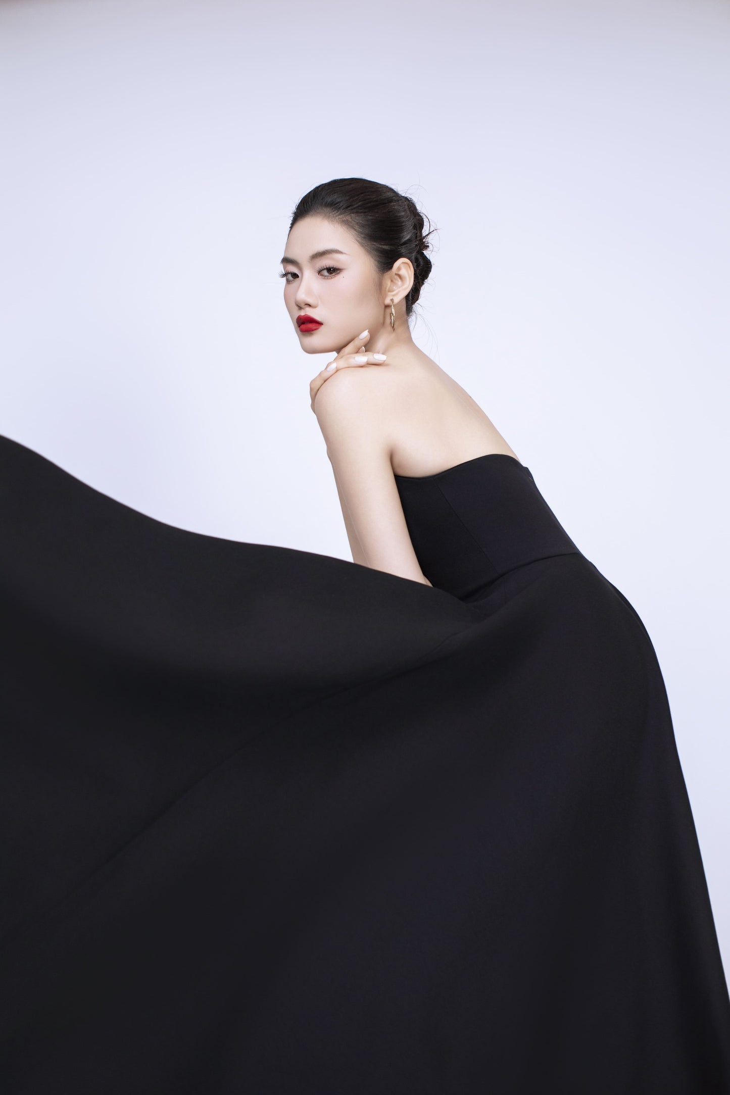 Side profile of Diana black dress showcasing flattering fit and flare silhouette