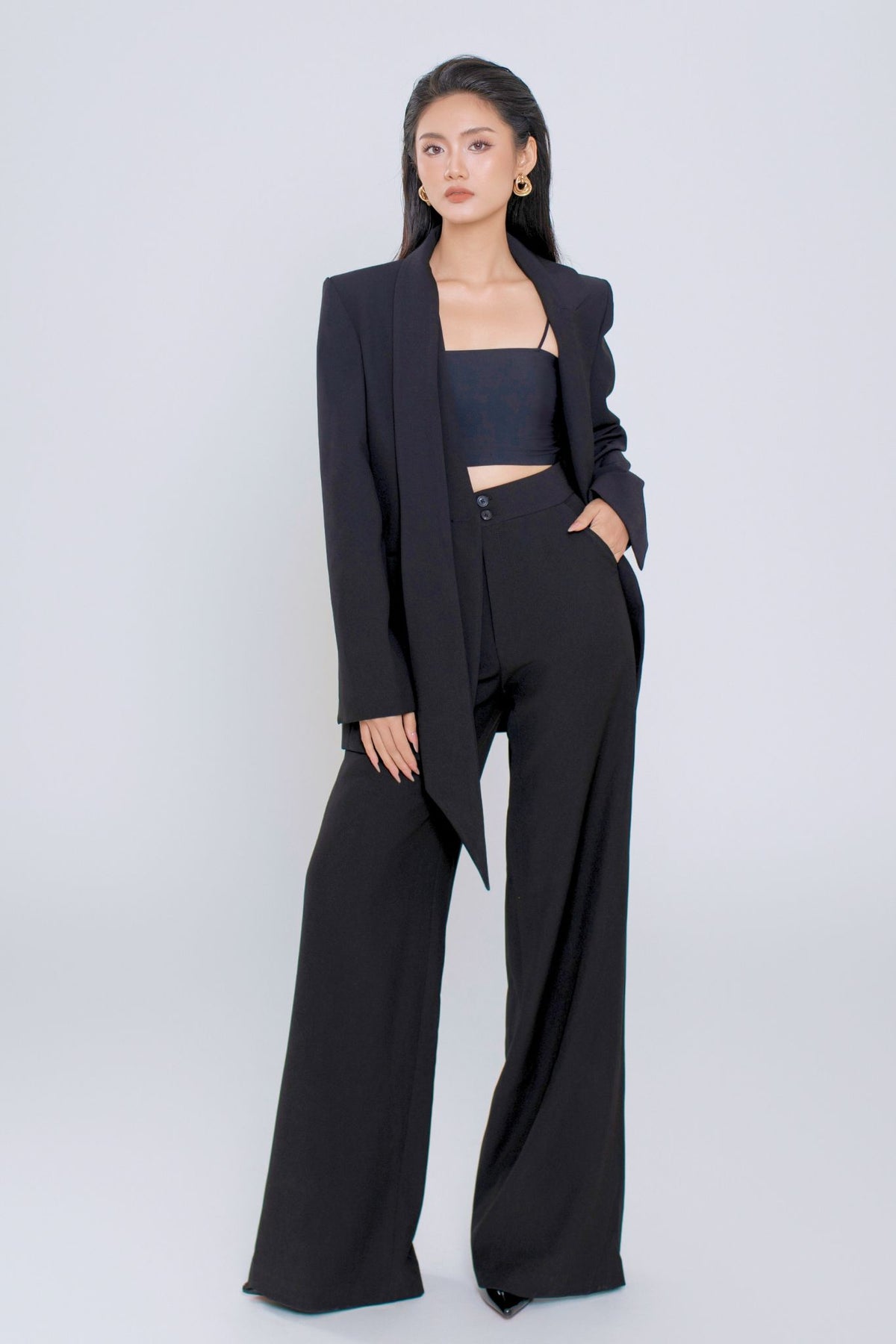Woman wearing a black suit with a white background