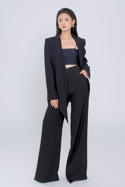 Woman wearing a black suit with a white background