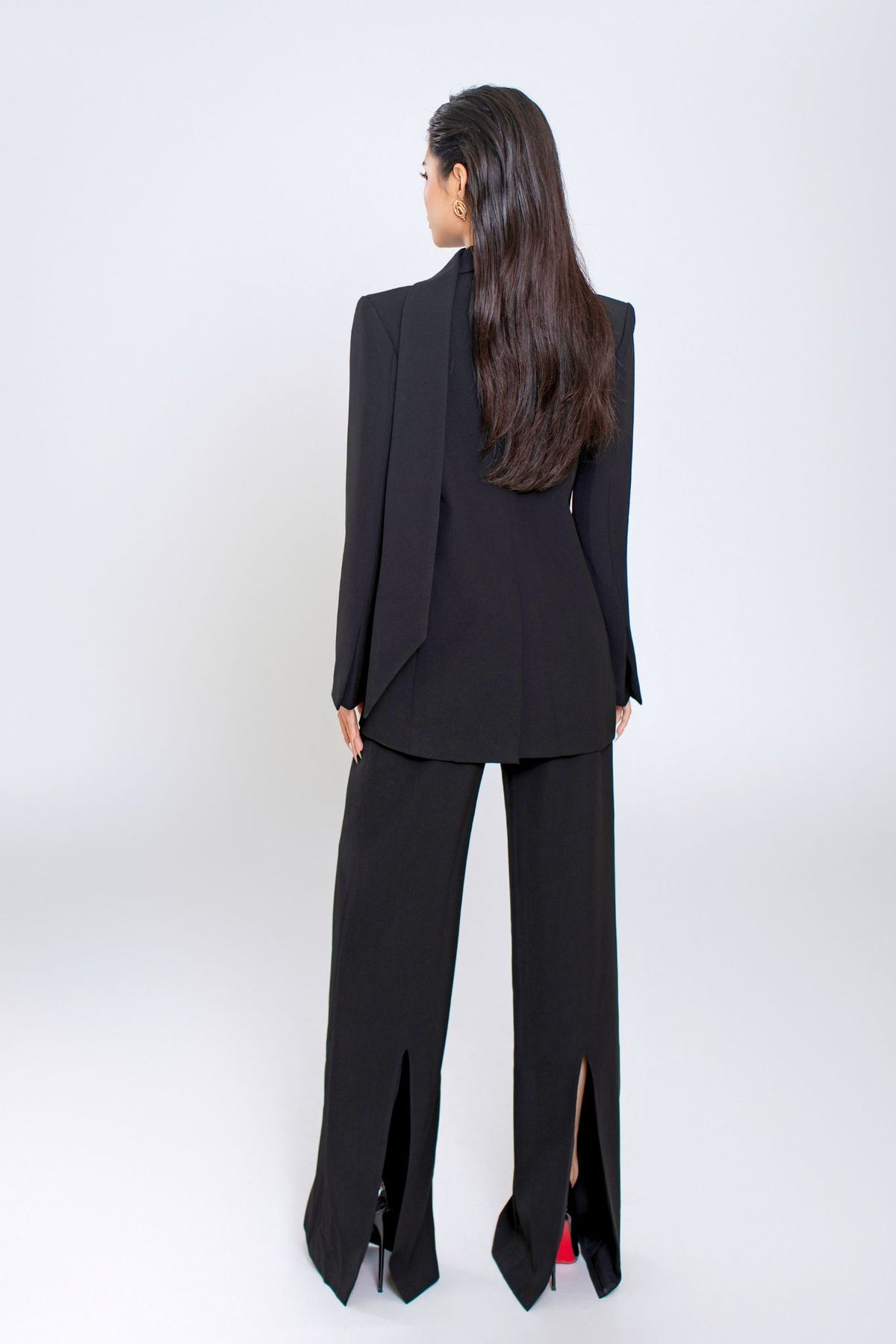 Person wearing a black suit with a white background