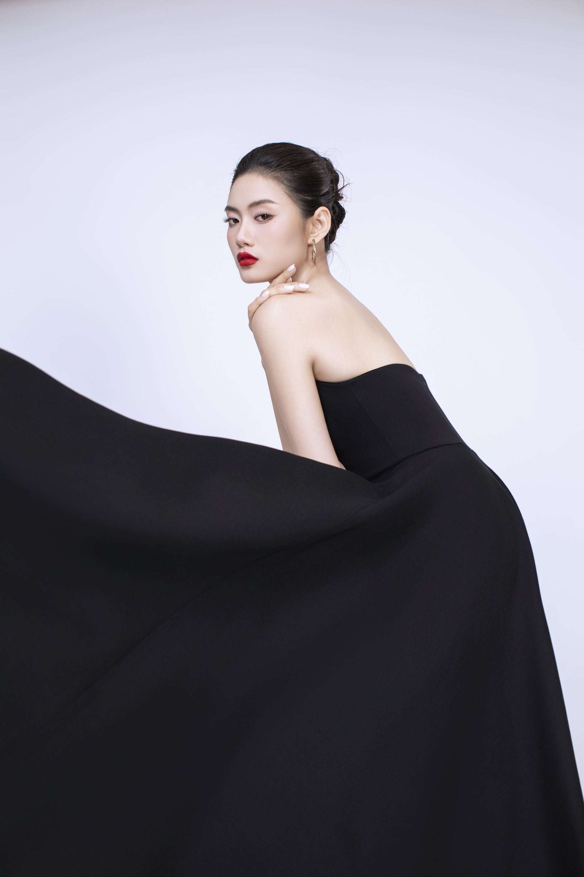 Side profile of Diana black dress showcasing flattering fit and flare silhouette