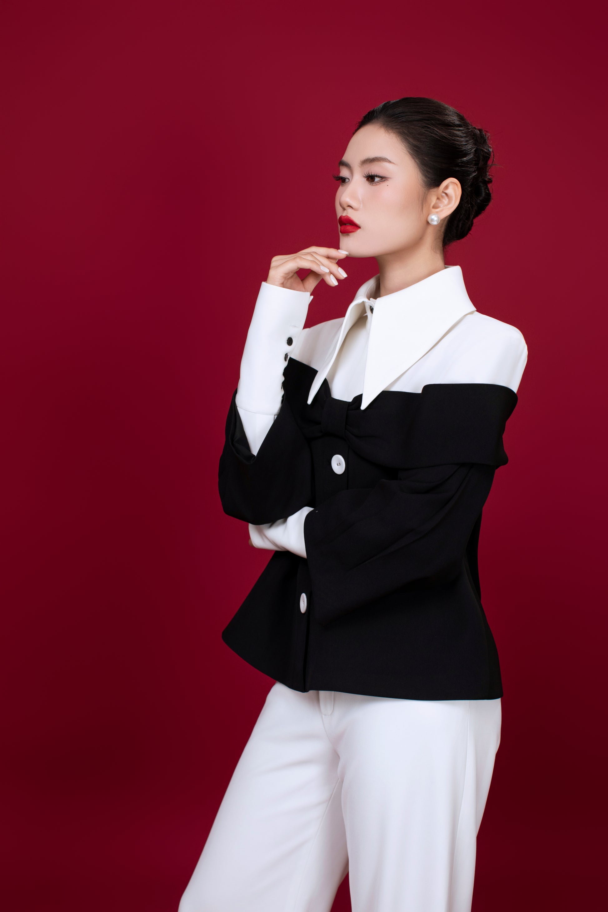 Side profile of Grace relaxed-fit top with padded shoulders and subtle sleeve detail